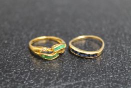 TWO 14K YELLOW METAL RINGS, one set with sapphires, the other with emeralds on a split band,