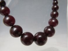 A CHERRY RED FATURAN AMBER GRADUATED CIRCULAR BEAD NECKLACE, approx L 44 cm, approx weight 35 g