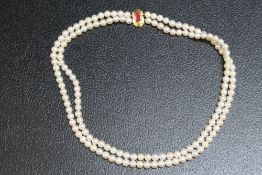 A DOUBLE ROW STRAND OF FRESHWATER PEARLS ON AN UNMARKED YELLOW METAL CLASP, approx 44 cm