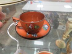 A WEDGWOOD 'ROSSO ANTICO' TERRACOTTA ENAMELLED CUP AND SAUCER