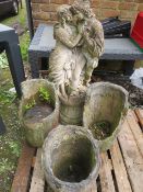 A CONCRETE STATUE ON PLINTH AND THREE RUSTIC CONCRETE PLANTERS