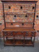 A GEORGIAN OPEN WELSH DRESSER OF SMALL PROPORTIONS, having an arrangement of five drawers, raised on
