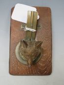 AN EARLY 20TH CENTURY COLD PAINTED FOXES HEAD, as a letter clip on a wooden base, L 14 cm, H 6.5 cm