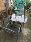 A MODERN FIVE PIECE GARDEN TABLE AND STACKING CHAIRS