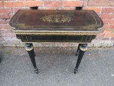 A 19TH CENTURY EBONISED AND BRASS INLAID FOLD-OVER GAMES TABLE, inlaid brass detail throughout and