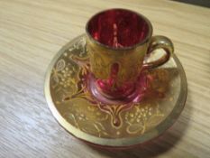 AN ANTIQUE CRANBERRY MOSER GLASS DEMITASSE GILDED CUP AND SAUCER