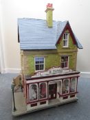 AN EXCELLENT QUALITY ROTATING BASE DOLLS HOUSE, complete with fixed furniture, has shop frontage,