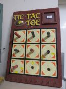 A PAINTED WOOD FAIRGROUND 'TIC TAC TOE' GAME BROWN PAINTED BACK BOARD, with red and black pegs, with