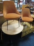 A MODERN CIRCULAR TABLE WITH TWO ORANGE CHAIRS