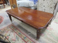A MAHOGANY COFFEE TABLE WITH BRASS CASTORS