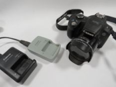 A CANON DIGITAL CAMERA SX50 HS TOGETHER WITH A BATTERY AND CHARGER (UNCHECKED)