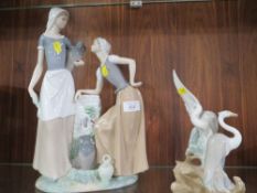A LARGE NAO FIGURE OF TWO GIRLS BY A WATER PUMP TOGETHER WITH A NAO FIGURE OF TWO BIRDS A/F