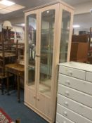 A modern limed and glazed display cabinet with cupboards below