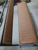 A modern industrial style metal bench with brown leather upholstered padding