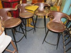 A modern set of four brown leather bar/kitchen stools