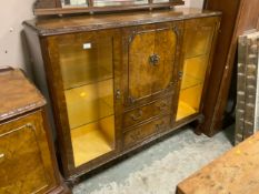 A 20th century walnut display cabinet with central cupboard and drawers