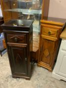 A pair of colonial hardwood style plant stands with a drawer and cupboard below, one darker than the