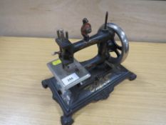 A VINTAGE MINATURE SEWING MACHINE WITH SPARES