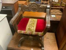 A carved colonial style X frame armchair