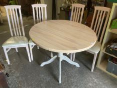 A modern limed style circular, extending dining table and four chairs
