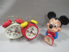 THREE VINTAGE DISNEY MICKY MOUSE CLOCKS TOGETHER WITH A PLASTIC MONEY BOX (NO STOPPER )