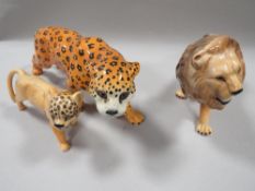 A BESWICK FIGURE OF A LION, A LEOPARD AND ANOTHER (3)