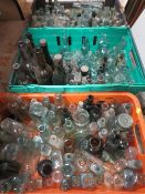A LARGE QUANTITY OF ASSORTED COLLECTABLE GLASS BOTTLES OVER THREE TRAYS