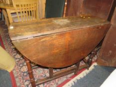 An antique oak drop leaf dining table with gate leg mechanism