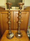 A pair of late 19th century turned oak candlesticks