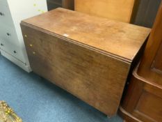 An antique oak heavy drop leaf dining table