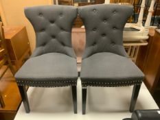 A pair of modern dark grey upholstered dining chairs