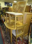 A modern beech style kitchen table and four chairs