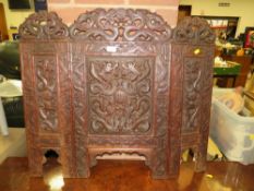 A carved Eastern hardwood fire screen with dragon detail