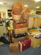 A large collection of vintage suitcases, wicker hampers and baskets