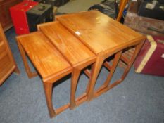 A nest of mid-century teak tables with marked top