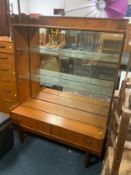 A mid-century teak glazed cabinet with two drawers below W 107 cm