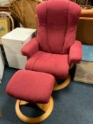 A modern upholstered arm reclining armchair with footstool