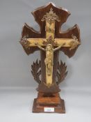 A gilt metal freestanding cross on wooden stand