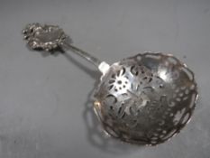 An antique silver sifter spoon by Bertold Muller