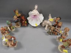 A selection of Goebel figures to include a gloss finish bear cub together with a Royal Doulton