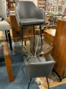 A modern circular glass top table with two armchairs