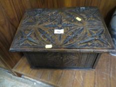 A heavily carved wooden box with hinged lid