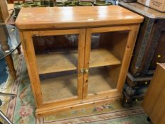 A honey pine glazed two door cabinet W 92 cm