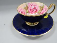 An Ansley gilded cobalt blue cup/saucer with floral interior
