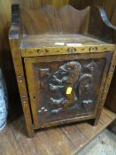 A heavily carved small wooden cupboard with rampant lion motif, locked - key in office