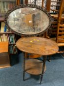 A carved oak wall mirror together with an oak occasional table