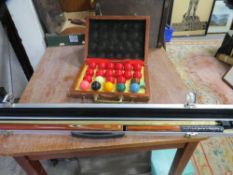 A boxed snooker cue and a set of snooker balls