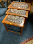 A mid-century teak tile top nest of tables