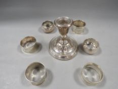 A hallmarked silver squat candlestick together with six assorted silver napkin rings