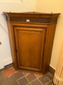 A Georgian oak cross banded corner, cupboard with shell inlay to the door